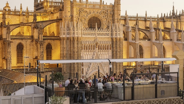 A historic building with intricate architecture, a covered outdoor seating area, and a view of the structure. - EME Catedral Mercer Hotel (Seville)