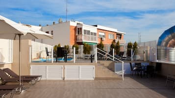 Een seizoensgebonden buitenzwembad en parasols bij het zwembad