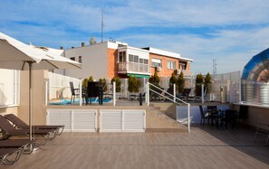 Una piscina al aire libre de temporada, sombrillas
