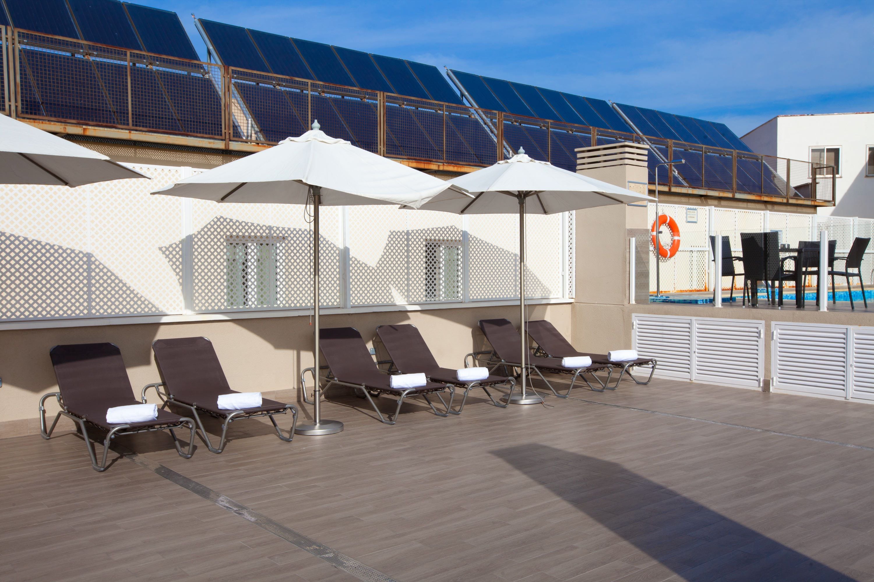 Een seizoensgebonden buitenzwembad, parasols voor strand/zwembad