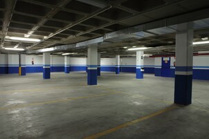 Eine mehrgeschossige Parkgarage mit Betonböden und blauen Säulen.