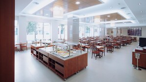 A spacious cafeteria with a buffet setup, large windows, and a modern ceiling design. - Hotel Porcel Ganivet (Madrid)