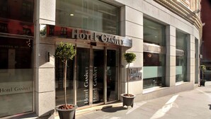 The exterior of Hotel Ganivet with large glass doors, potted plants, and a clear view of the entrance. - Hotel Porcel Ganivet (Madrid)
