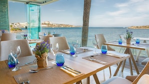 Un restaurante con mesas dispuestas para comer, con vista al mar.