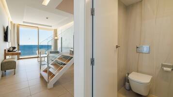 A modern hotel room with a balcony, a staircase, and a bathroom.
