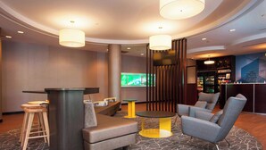 A lobby area with a bar, seating, and a television. - SpringHill Suites by Marriott Birmingham Colonnade (Birmingham)
