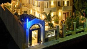 Ein mehrstöckiges Hotel mit einem markanten Bogenportal und einem Schild, das es als Hotel kennzeichnet.