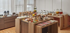 Un bufé de desayuno con diversas opciones de comida y bebidas.
