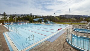 A large indoor swimming pool with multiple lanes, a diving platform, and a small slide. - Hotel Edda Egilsstadir (Egilsstaðir)