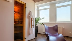 Habitació moderna amb un armari de fusta, una finestra gran i una planta en test.