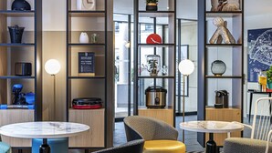A modern interior with a coffee machine, a clock, and a menu board.