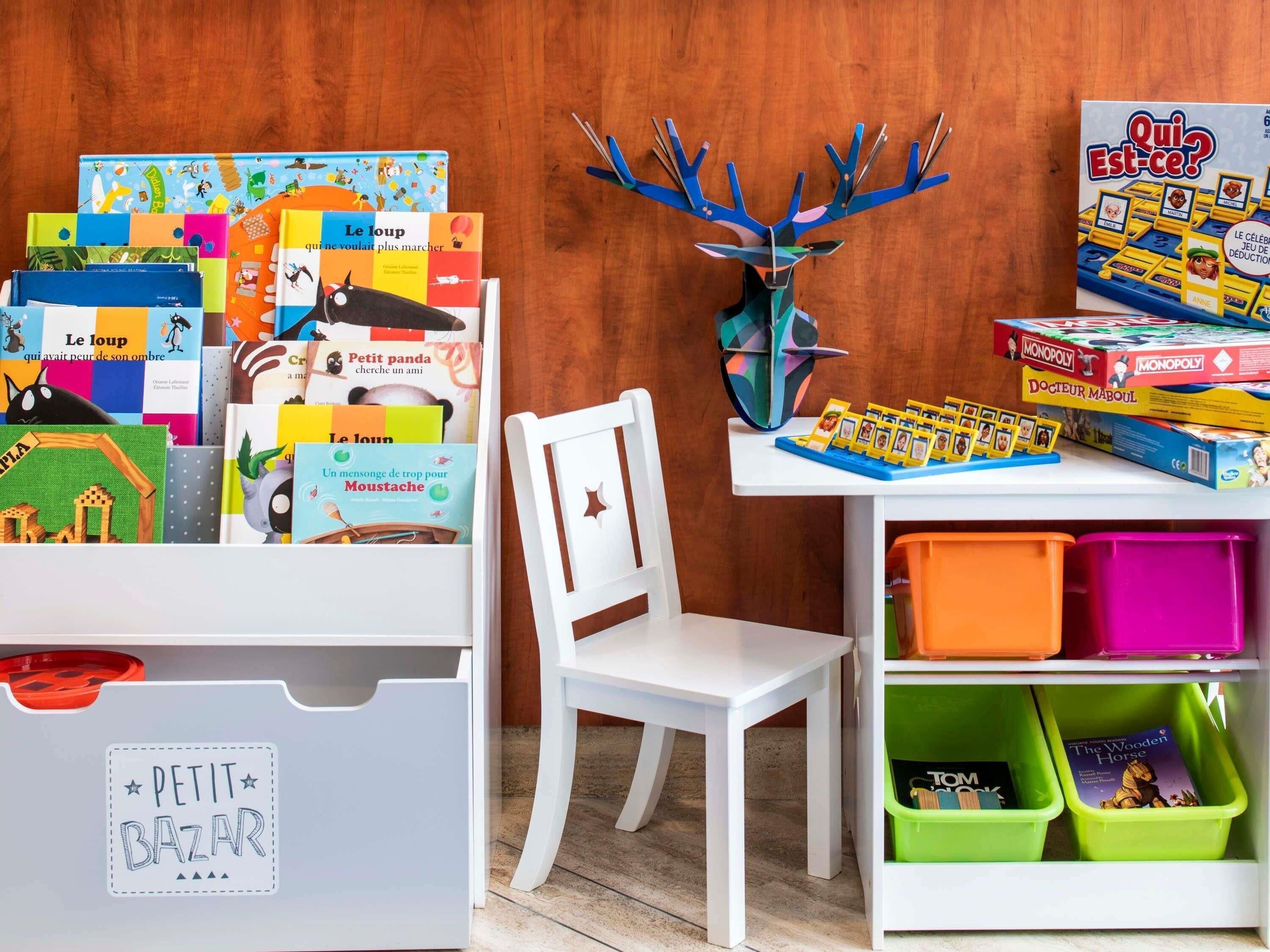 Habitación infantil con libros educativos, un juego de Monopoly y una decoración con cabeza de ciervo.