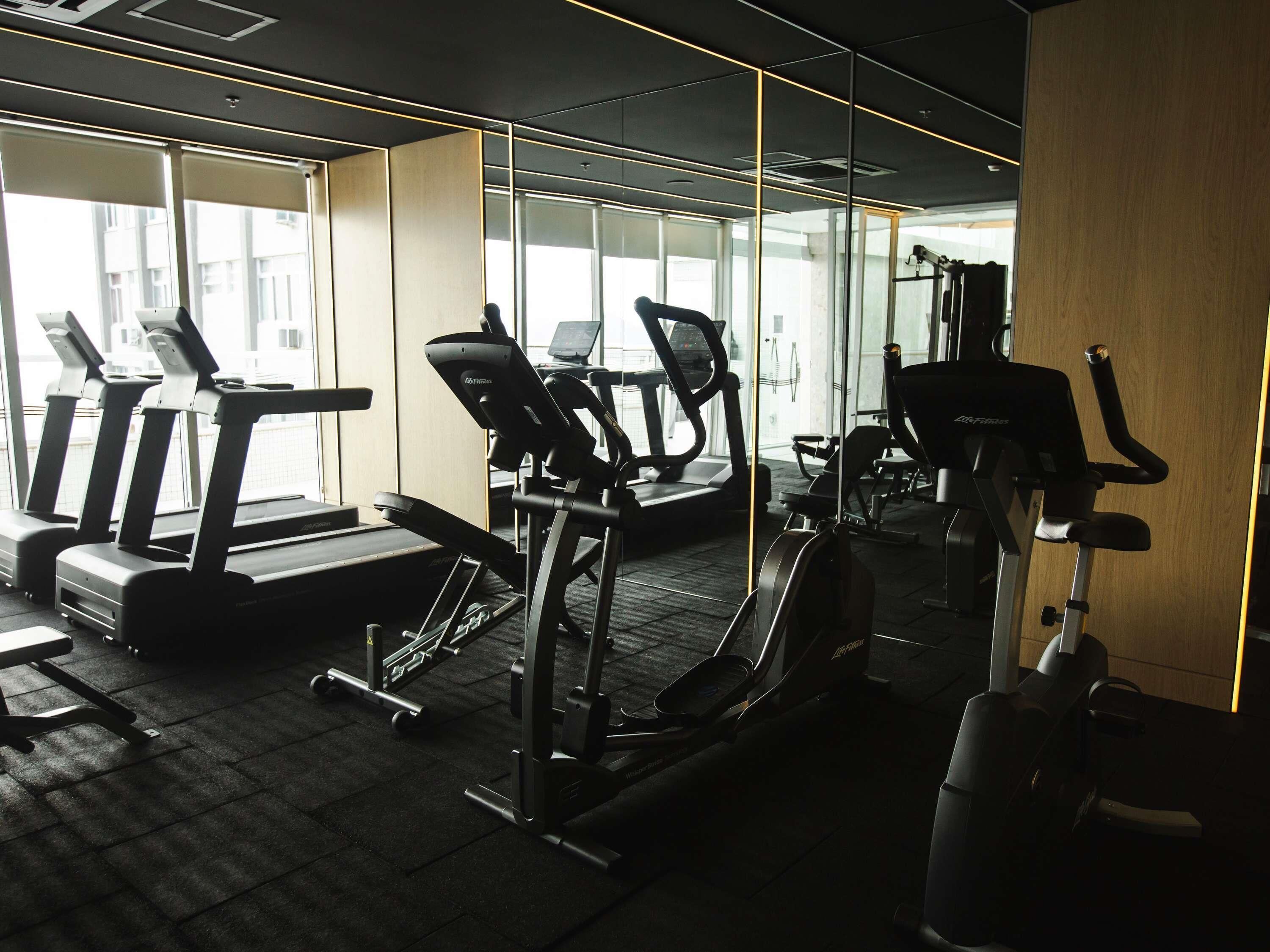 A gym with treadmills, elliptical machines, and weight equipment.