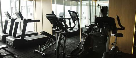 A gym with treadmills, elliptical machines, and weight equipment.
