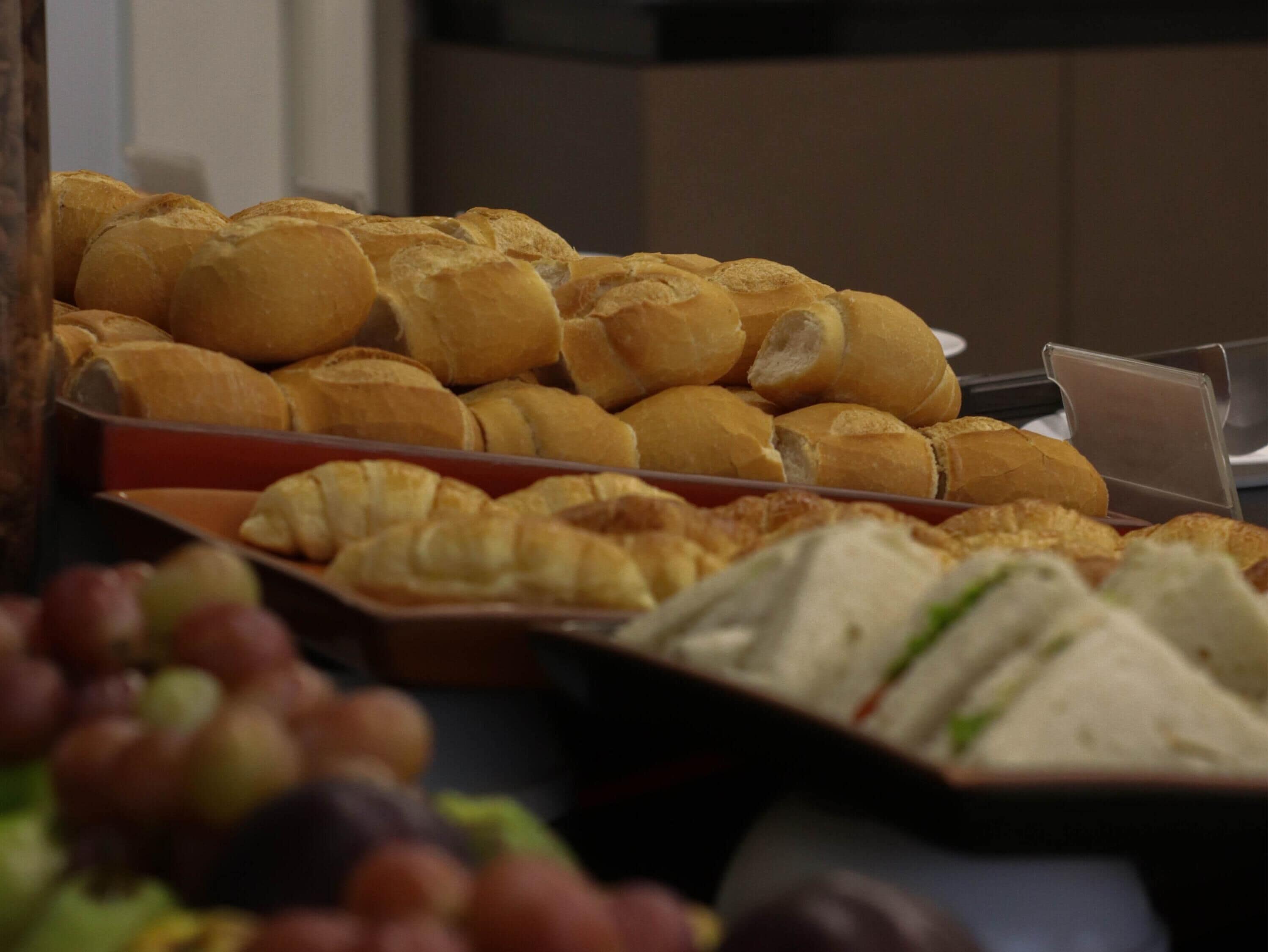 A buffet with various food items including sandwiches and pastries.