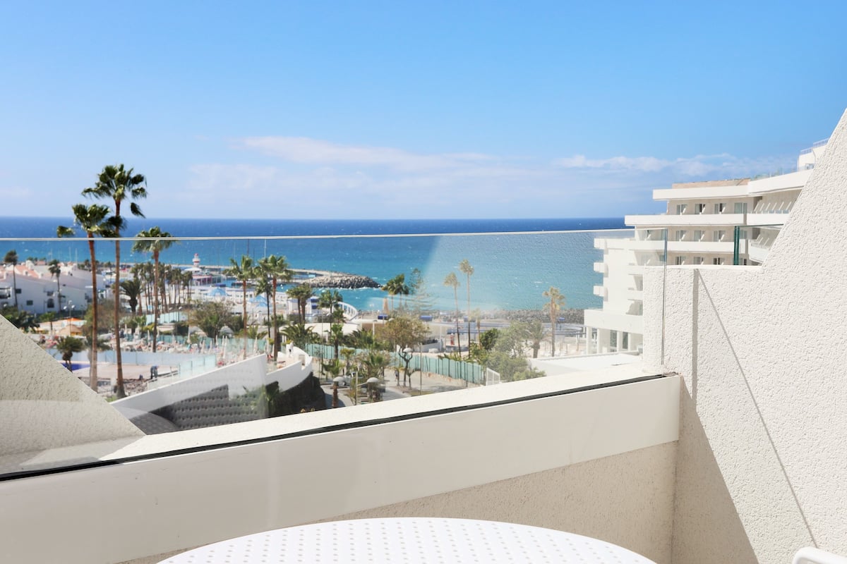 A balcony with a view of the beach and ocean.