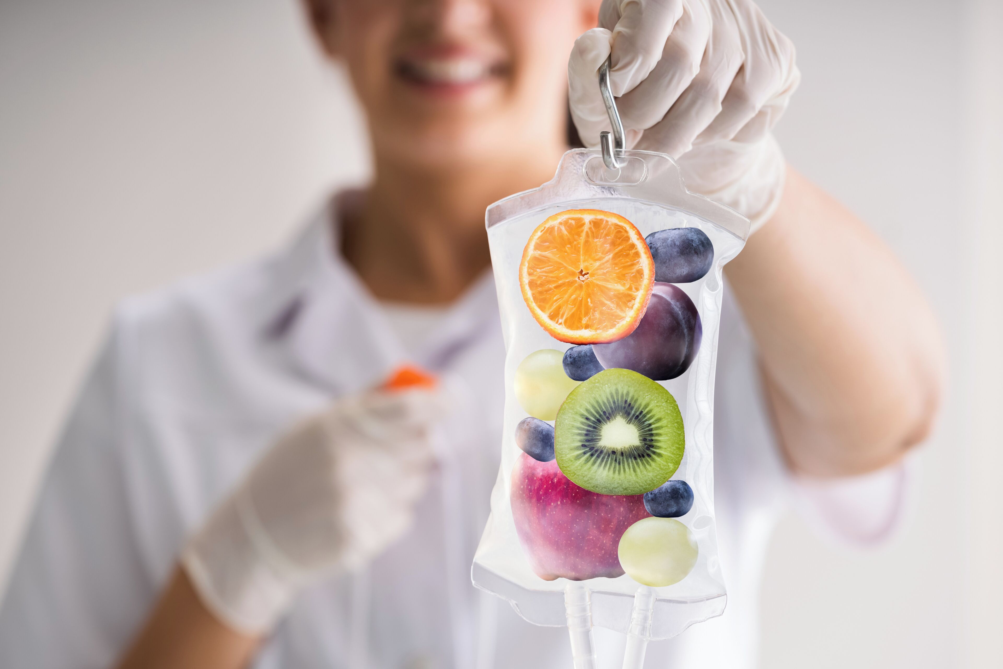 Iemand houdt een doorzichtige plastic zak vol met verschillende soorten fruit.