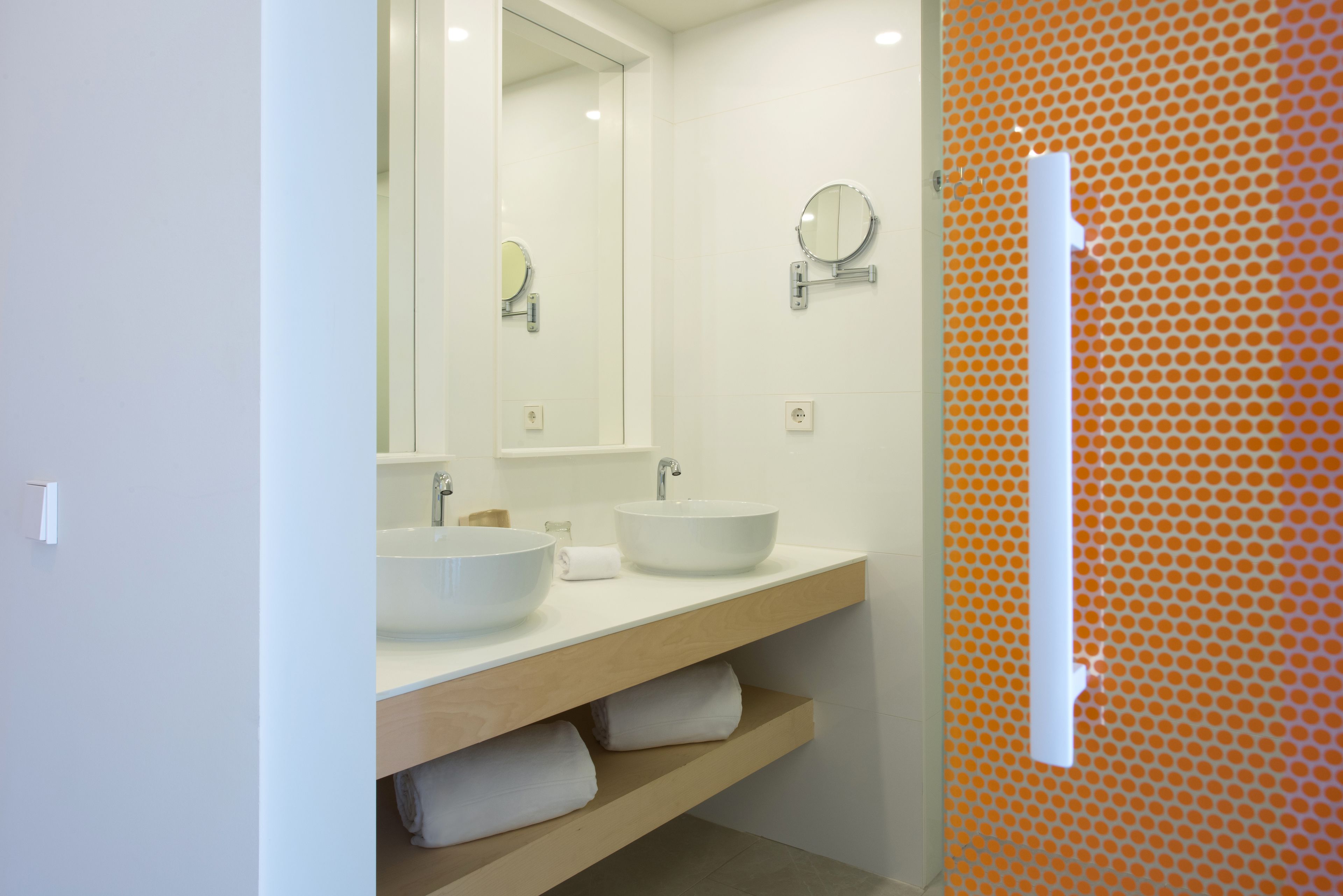 A bathroom with two sinks, a mirror, and a towel rack.