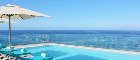 Piscine extérieure, parasols de plage, chaises longues