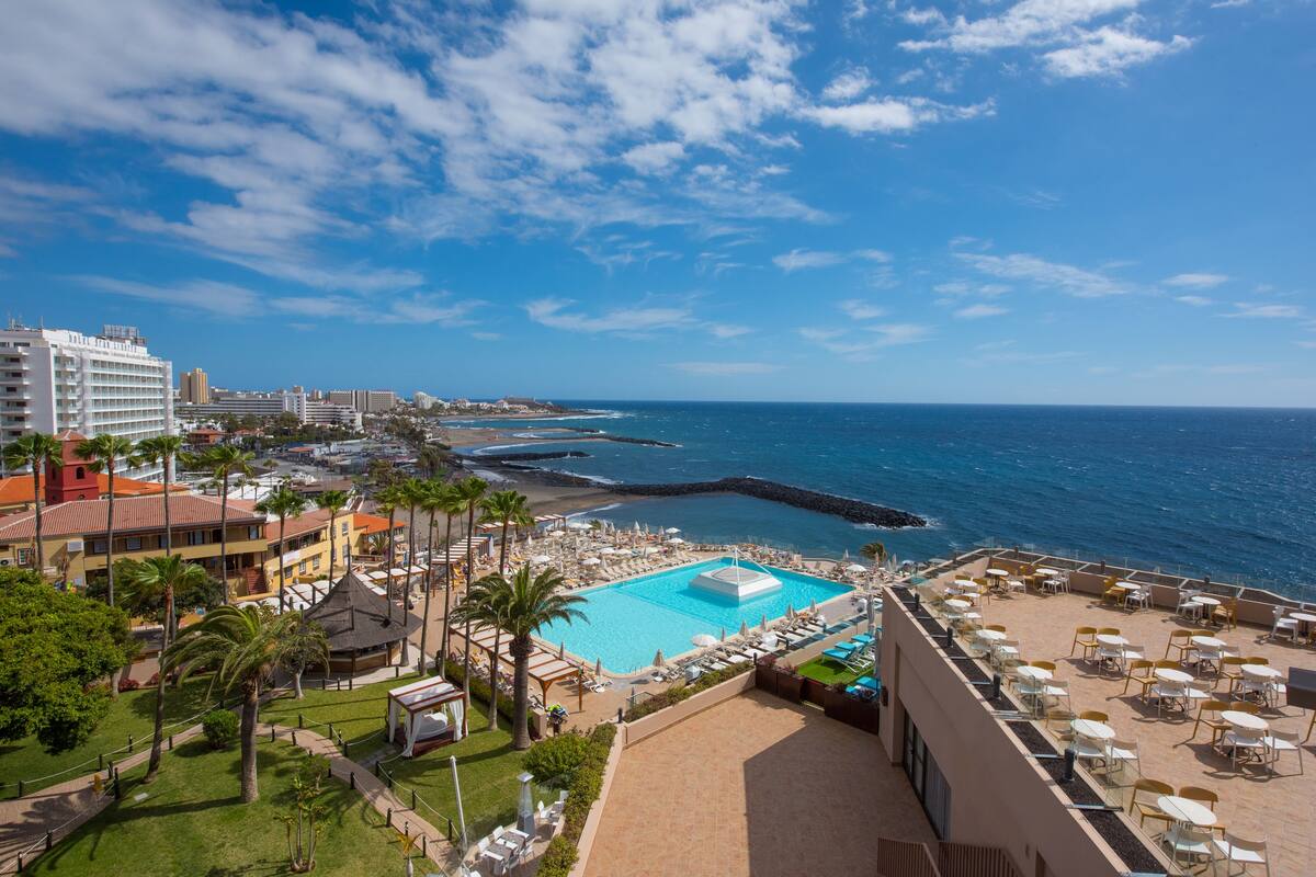 Um resort com piscina, praia e vista para o oceano.