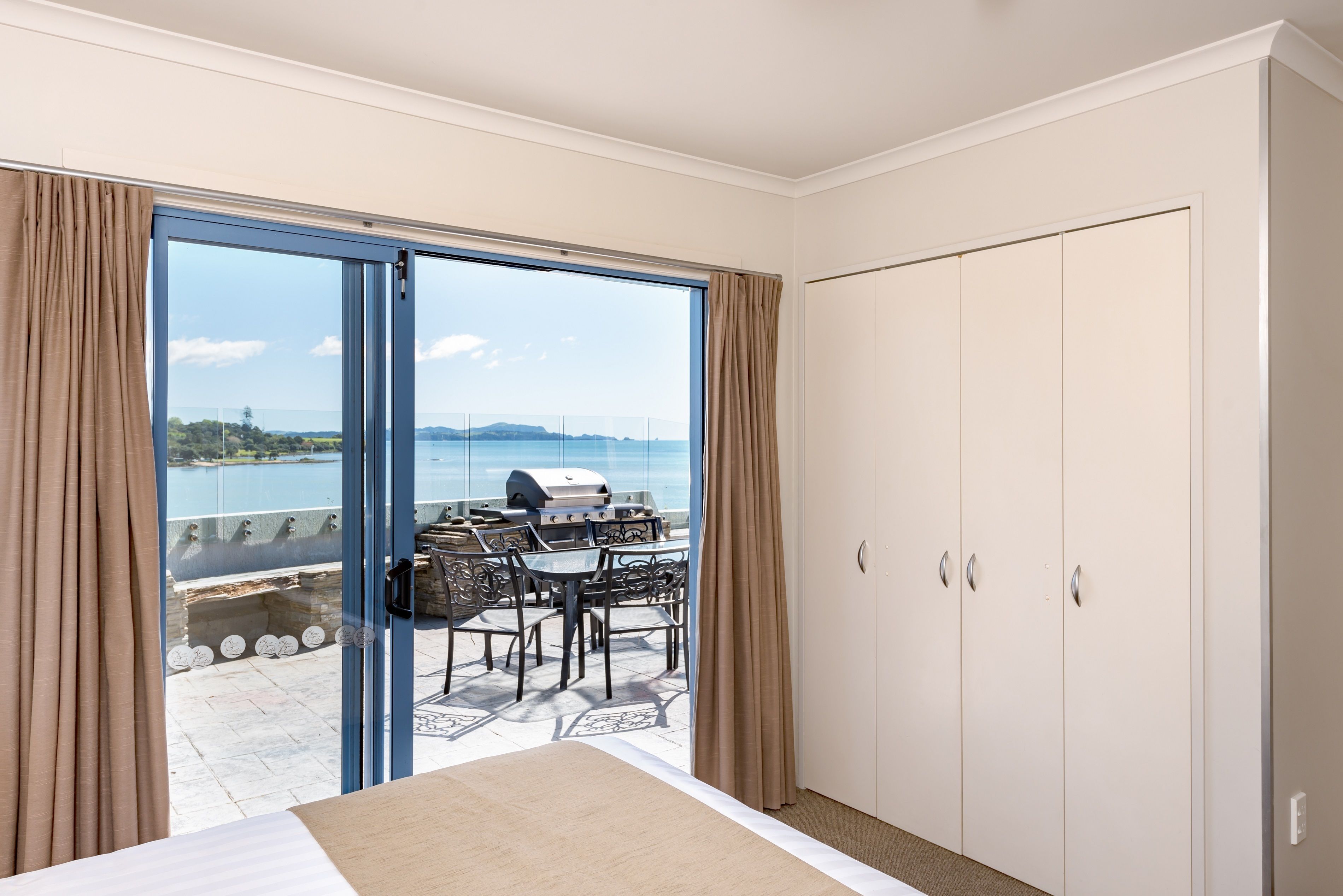 Une chambre d’hôtel avec balcon, une table à manger et vue sur la mer.