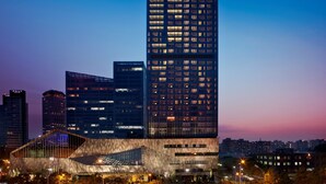 A high-rise hotel with a prominent "Westin" sign, featuring a modern glass facade and multiple illuminated windows. - The Westin Beijing Chaoyang (Beijing)