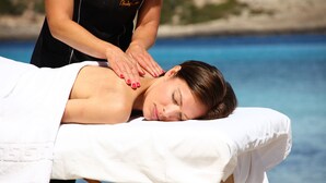 A person receiving a back massage by a masseuse at a beachside spa. - Sandos El Greco Hotel - Adults Only (Sant Joan de Labritja)