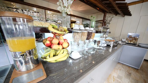 A buffet counter with a variety of food items, including fruits, cereals, and beverages. - Hotel Europa Offenbach (Offenbach am Main)