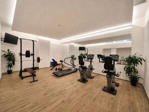A modern gym with various exercise equipment, including a treadmill, weight bench, and stationary bikes. - Smy Bologna Centrale (Bologna)