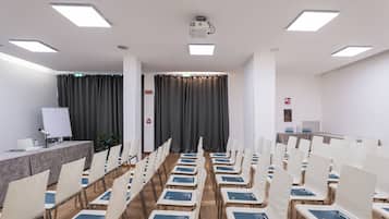 A conference room with rows of chairs, a projector, and a whiteboard.
