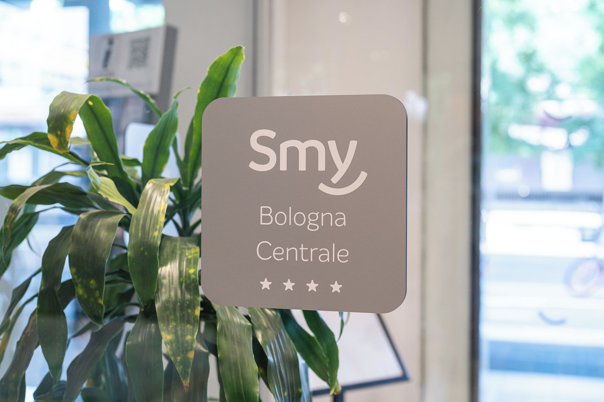 A sign with the name 'Smy' and the location 'Bologna Centrale' with a five-star rating.