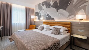 A hotel room with a large bed, a headboard, two bedside lamps, a nightstand, and a large abstract wall mural. - Hotel Ivka (Dubrovnik)