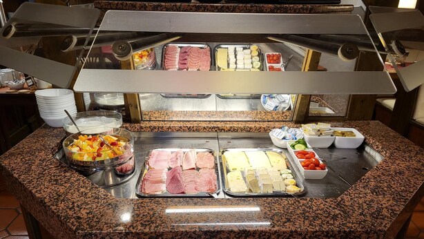 A buffet counter with various food items including meats, cheeses, and fruits. - Historikhotel Ochsen (Tamm)