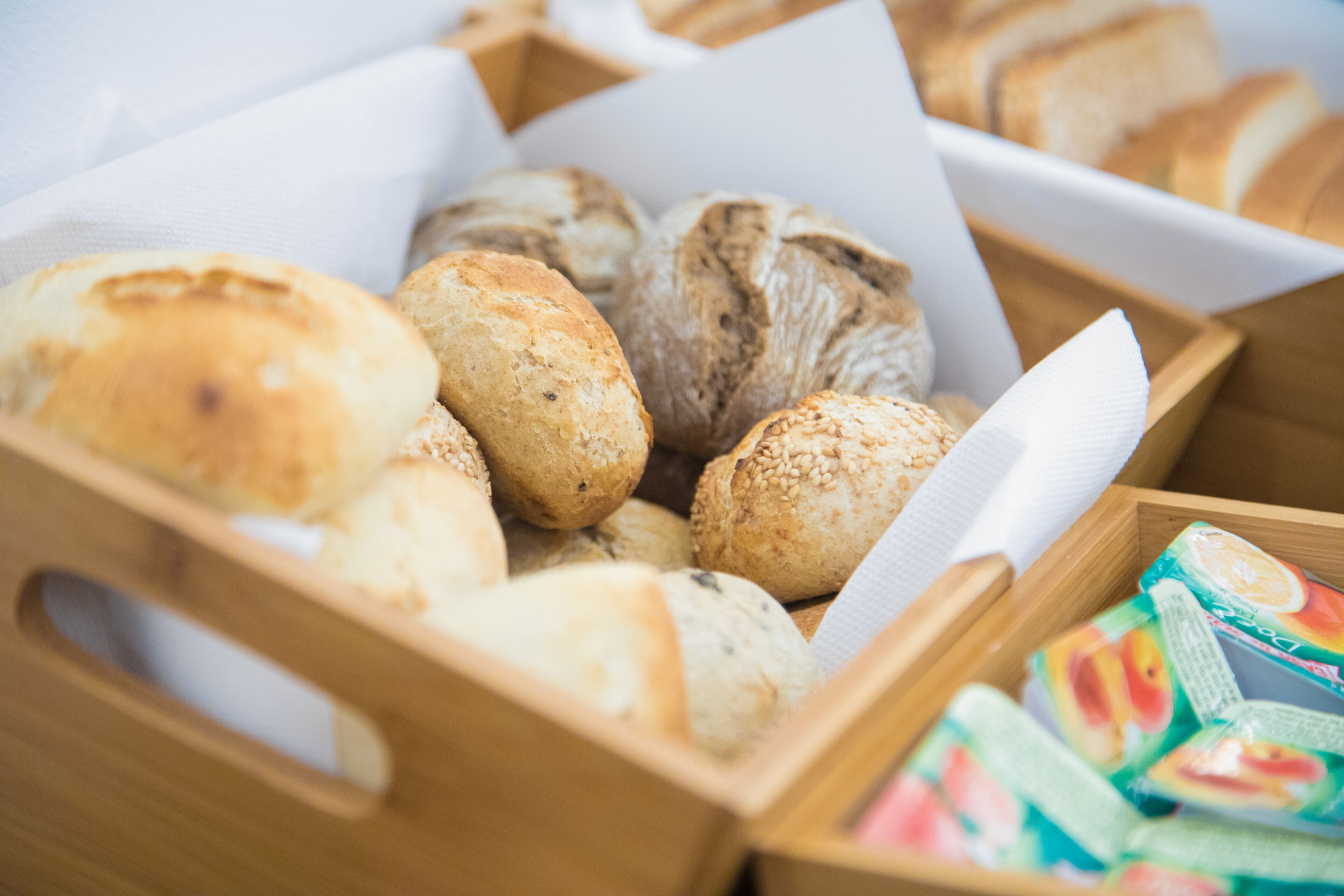 Una caja de madera con diferentes tipos de pan y aperitivos envasados.