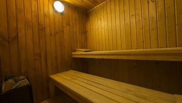 Una sauna de madera con bancos y un banco en el suelo.