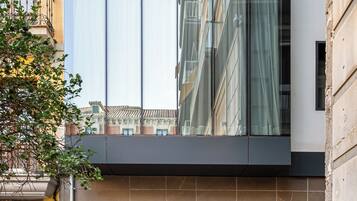 Een modern gebouw met grote ramen, een duidelijke ingang en een bord dat een locatie aangeeft.