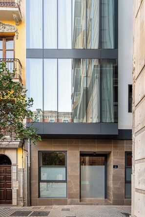 A modern building with large windows, a visible entrance, and a sign indicating a location. - Room Mate Leo, Granada (Granada)