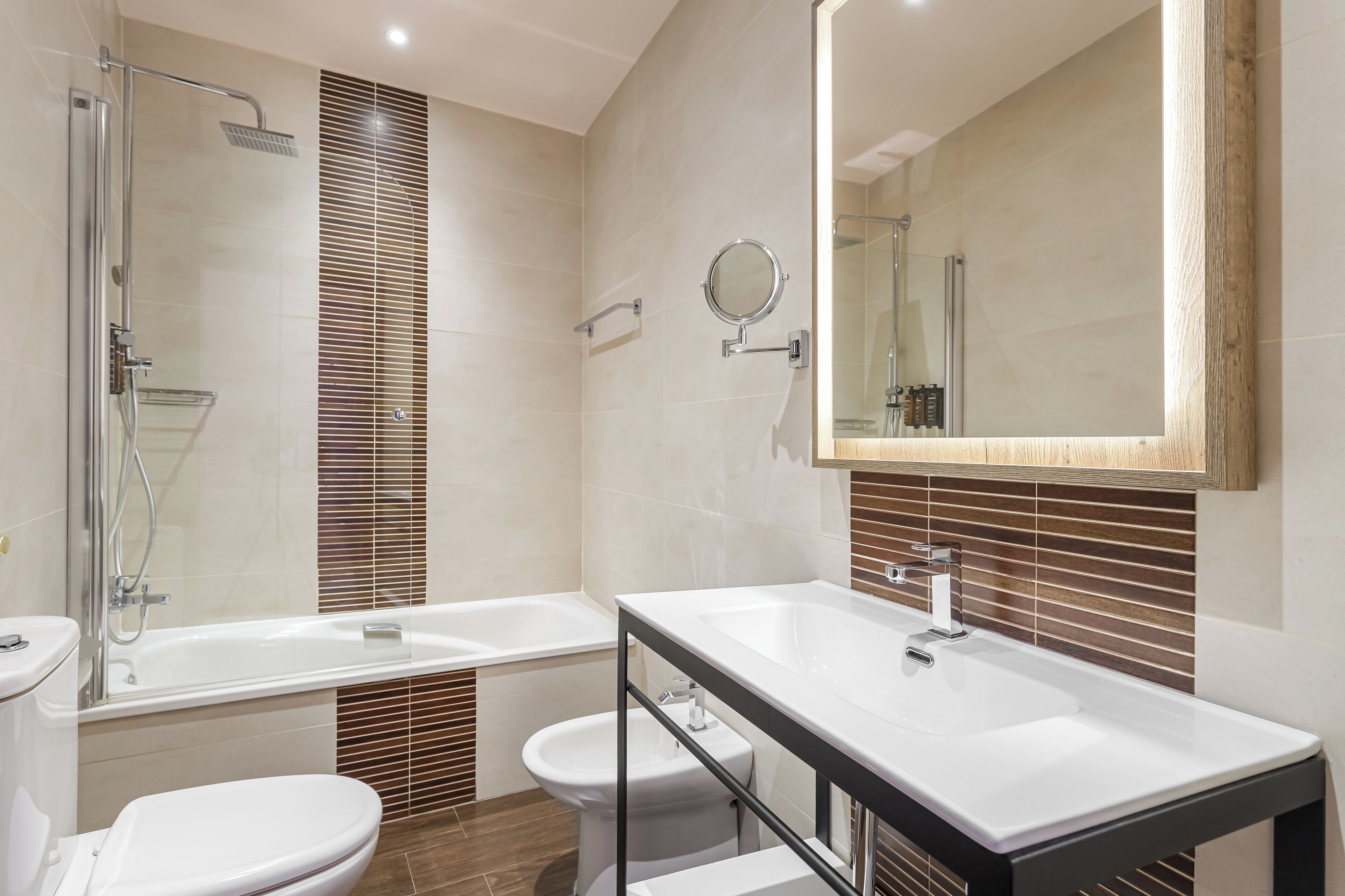 A modern bathroom with a glass-enclosed shower, a double sink vanity, and a toilet.