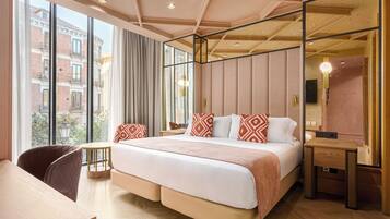 Een moderne hotelkamer met een groot bed, een bureau en uitzicht op de stad.