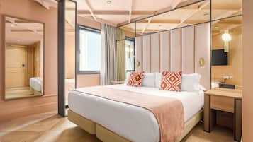 Een moderne hotelkamer met een groot bed, een nachtkastje, een spiegel en uitzicht op de badkamer.