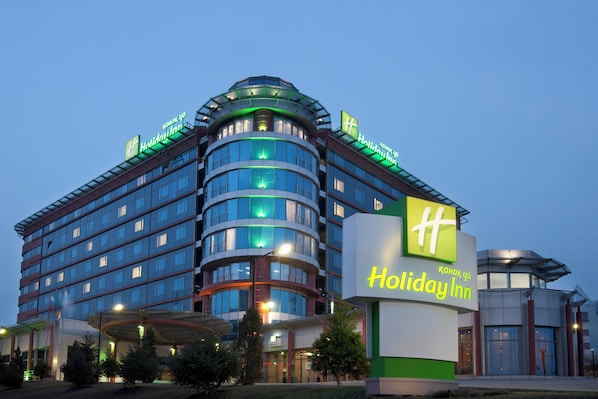 A Holiday Inn hotel with a modern design, featuring multiple floors and a prominent signage.