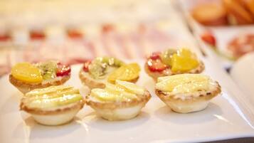 Een bordje met kleine gebakjes en fruit.