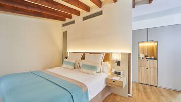 A bedroom with a bed, bedside table, lamp, and a view of a bathroom.