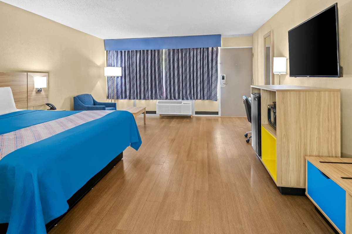 Une chambre d’hôtel équipée d’un lit, d’un bureau, d’une chaise, d’une télévision et d’un appareil de climatisation.