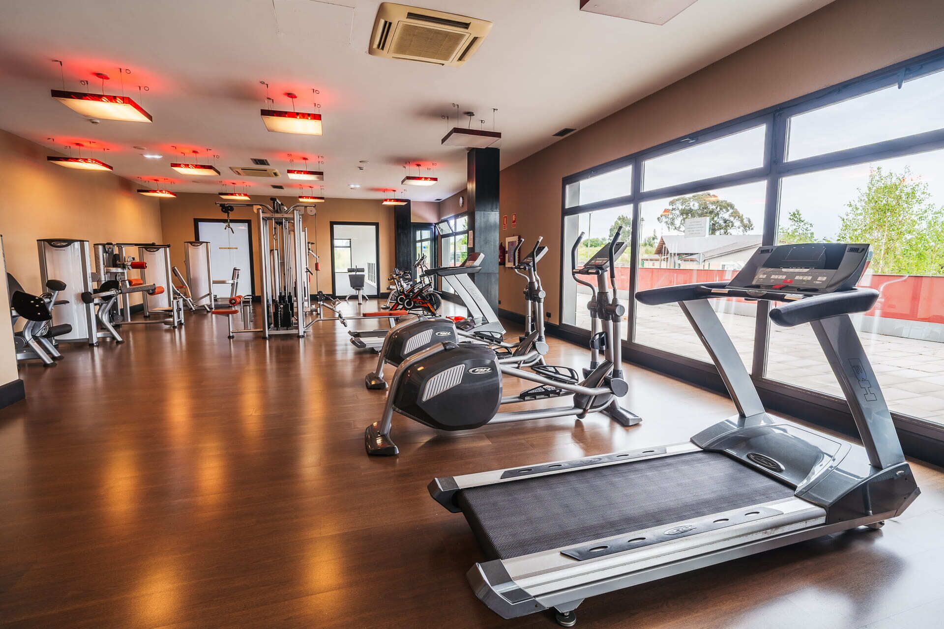 A gym with treadmills, elliptical machines, and weight equipment.
