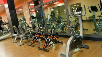 Un gimnasio con bicicletas estáticas, cintas de correr y equipo de ejercicio.