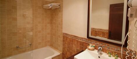 A bathroom with a bathtub, toilet, sink, and a hairdryer.