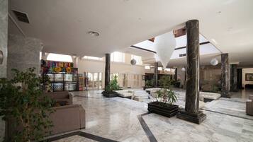 A spacious lobby with marble flooring, large columns, and a variety of seating areas.