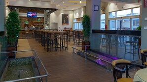 A spacious indoor area with multiple seating arrangements, a bar area, and a large window providing natural light. - Hotel Ezzahra Dar Tunis (Ezzahra)