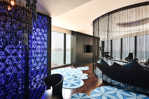 A modern interior with a curved seating area, a patterned wall, and a view of the city.